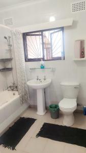 a bathroom with a sink and a toilet and a tub at Pumula on 5th in Pumula +24 photos