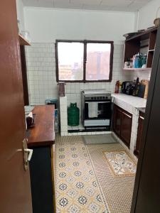 a kitchen with a stove and a tile floor at Résidence avec gardien en plein centre de Bonapriso proche aéroport in Douala