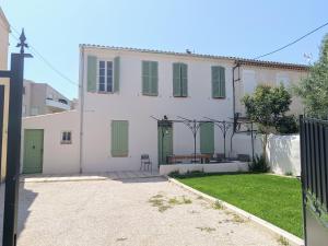 une maison blanche avec des portes vertes et une cour dans l'établissement Maison entre Port et Calanques, à La Ciotat