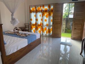 a bedroom with a bed and a window with flowers at The Pearl Villa Ahangama in Ahangama