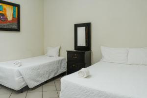 a bedroom with two beds and a mirror at Papaya Lodge in La Libertad