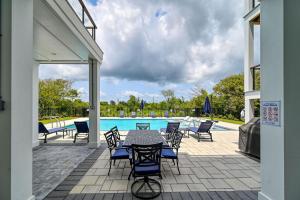 Un patio con mesa y sillas junto a una piscina. en Panoramic Ocean Views - Private Pool - Pickleball Court - Luxury Design Build, en North Topsail Beach 66 fotos más