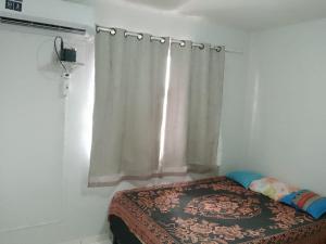 1 dormitorio con 1 cama con cortina y ventana en AP Super Life Castanhal-Pa, en Castanhal