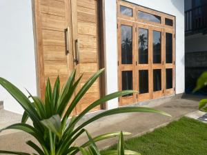 a wooden door of a house with a plant at The Pearl Villa Ahangama in Ahangama