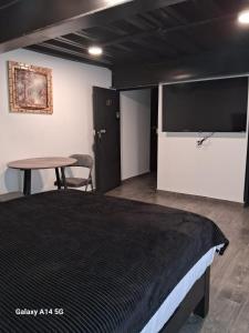 a bedroom with a bed and a table and a tv at La morada Enamorada in Mexico City +22 photos