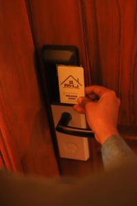 a person is holding a card on a door at River House Lodge International in Arusha