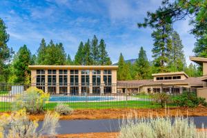 a large house with a pool in front of it at Black Butte Manor Bordering Forest in Black Butte Ranch