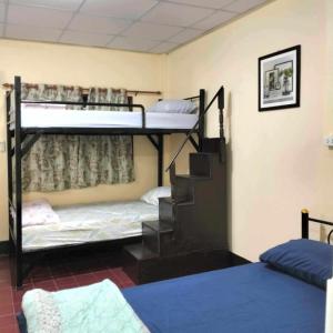 ein Zimmer mit zwei Etagenbetten und einer Treppe in der Unterkunft Manu V House in Phra Nakhon Si Ayutthaya