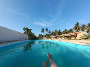a person laying on the edge of a swimming pool at Oásis in Beberibe