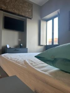 a bedroom with a bed with a television and two windows at Appartamento Lepanto in Marina di Gioiosa Ionica
