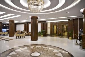 een lobby met een kroonluchter en tafels en stoelen bij بيستانا للشقق المخدومة 2 in Riyad