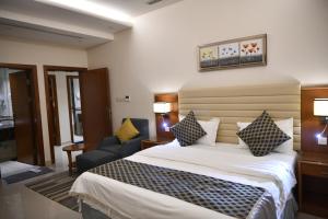 een hotelkamer met een bed en een stoel bij بيستانا للشقق المخدومة 2 in Riyad +54 foto's