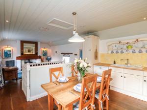 a kitchen with a wooden table and a dining room at Trehan in St Ives