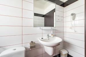 a white bathroom with a sink and a toilet at Domki Letniskowe Bursztynek in Grzybowo +153 photos