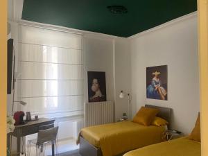 a bedroom with two beds and a green ceiling at B&B Liberty in Santa Maria Capua Vetere