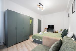 a bedroom with a bed and a couch at Flowers Grand Hotel Bucharest in Bucharest