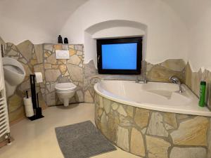 a bathroom with a large tub and a toilet at Haus Wildblick in Fladnitz an der Teichalm +53 photos