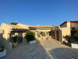 a house with a courtyard with potted plants at Villa Corallo in Costa Rei