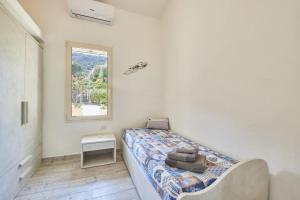 a small bedroom with a bed and a window at Villa Corallo in Costa Rei +12 photos