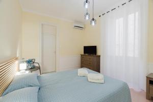 a bedroom with a blue bed and a television at Casetta Fardella 95 in Trapani