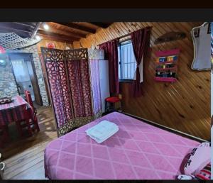 a bedroom with a pink bed in a room at Cabaña 'Te para Tres' in Merlo