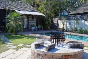 a backyard with a pool and a table and chairs at A Traveller's Palm in Phalaborwa