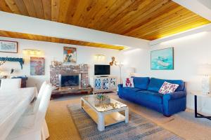 Una sala de estar con un sofá azul y una chimenea. en West Beach Retreat, en Oak Harbor