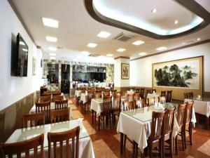 une salle à manger avec des tables et des chaises blanches dans un restaurant dans l'établissement Incheon Airporthotel Airstay, à Incheon