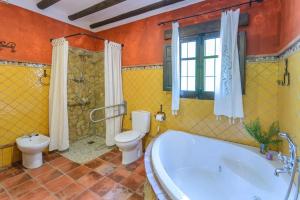 a bathroom with a tub and a toilet and a sink at Spacious villa with pool in Priego de Córdoba - 350 m² in Priego de Córdoba +54 photos