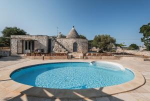 einen Pool vor einem Steinhaus in der Unterkunft Trullo Cupido Cinquenoci in Locorotondo