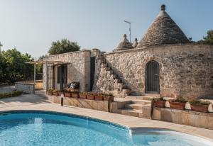 ein Haus mit einem Swimmingpool vor einem Gebäude in der Unterkunft Trullo Cupido Cinquenoci in Locorotondo