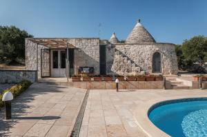 eine Villa mit einem Pool und einem Gebäude in der Unterkunft Trullo Cupido Cinquenoci in Locorotondo