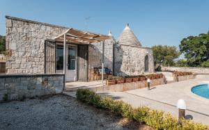 ein Haus mit einem Steingebäude und einem Pool in der Unterkunft Trullo Cupido Cinquenoci in Locorotondo