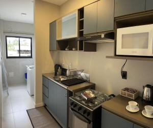 a small kitchen with a stove and a microwave at Apartmento Heizinger in Pomerode