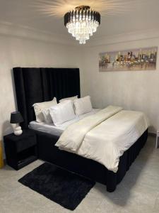 a bedroom with a large bed with a chandelier at Comfort et style au coeur de la ville in Lomé