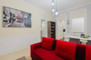 a living room with a red couch in a room at Casetta Fardella 95 in Trapani