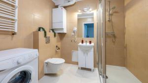 a bathroom with a washing machine and a shower at Apartamenty Karpacz in Karpacz +8 photos