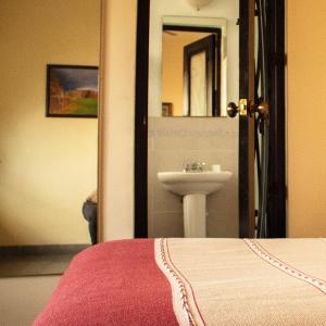 a bathroom with a bed and a sink and a mirror at ROSA BARROCO in Morelia