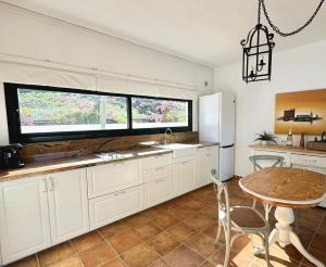 a kitchen with white cabinets and a table and a window at Finca El Pedregal - Suite Aloe in Haría