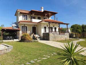 a large house with a porch and a yard at Νική κοσμά πηγάδι in Metamorfosi