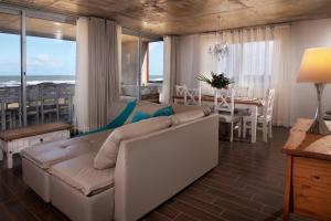 a living room with a couch and a dining room with a table at The Beach in La Paloma