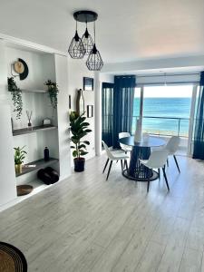 una sala da pranzo con tavolo e sedie e l'oceano di Le Pic D'Etretat a Étretat