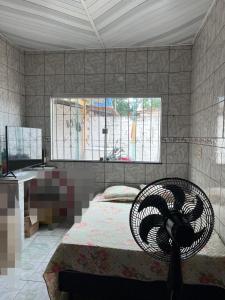 a bedroom with a bed and a desk and a window at Casa da Vanessa in Ananindeua