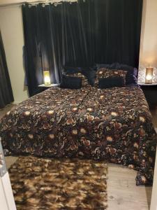 a bedroom with a large bed with a flowered blanket at Modern house in Lavangen