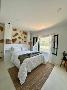 a bedroom with a large bed and a window at Finca El Pedregal - Suite Olivo in Haría