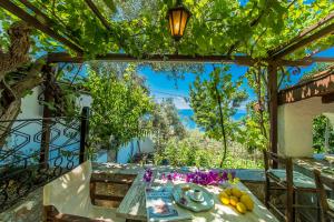 a table under a pergola with a table and fruits at Pounda Paou in Metókhion