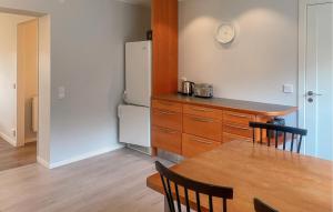 a kitchen with a table and a refrigerator at Hällgården in Vena
