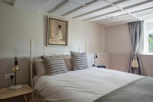 a bedroom with a white bed with pillows at Malvern hills, beautiful garden flat Twohundredandseven in Malvern Wells