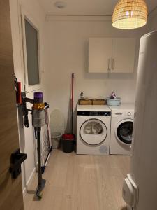 a kitchen with a washing machine and a washer at Jolie Villa avec bain balnéothérapie in Colombiers