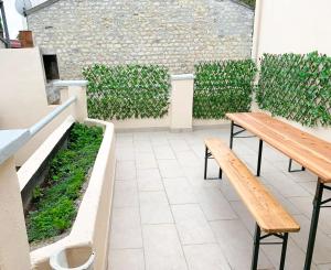 a patio with two benches and a hedge at Studio rénové, cuisine équipée in La Courneuve